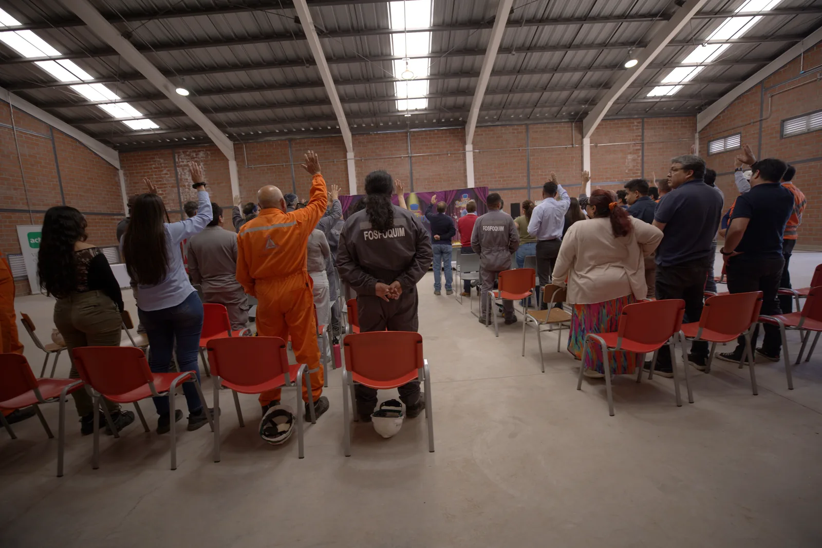 Trabajadores de una planta industrial participando en una charla de prevención de riesgos de Magisteria.