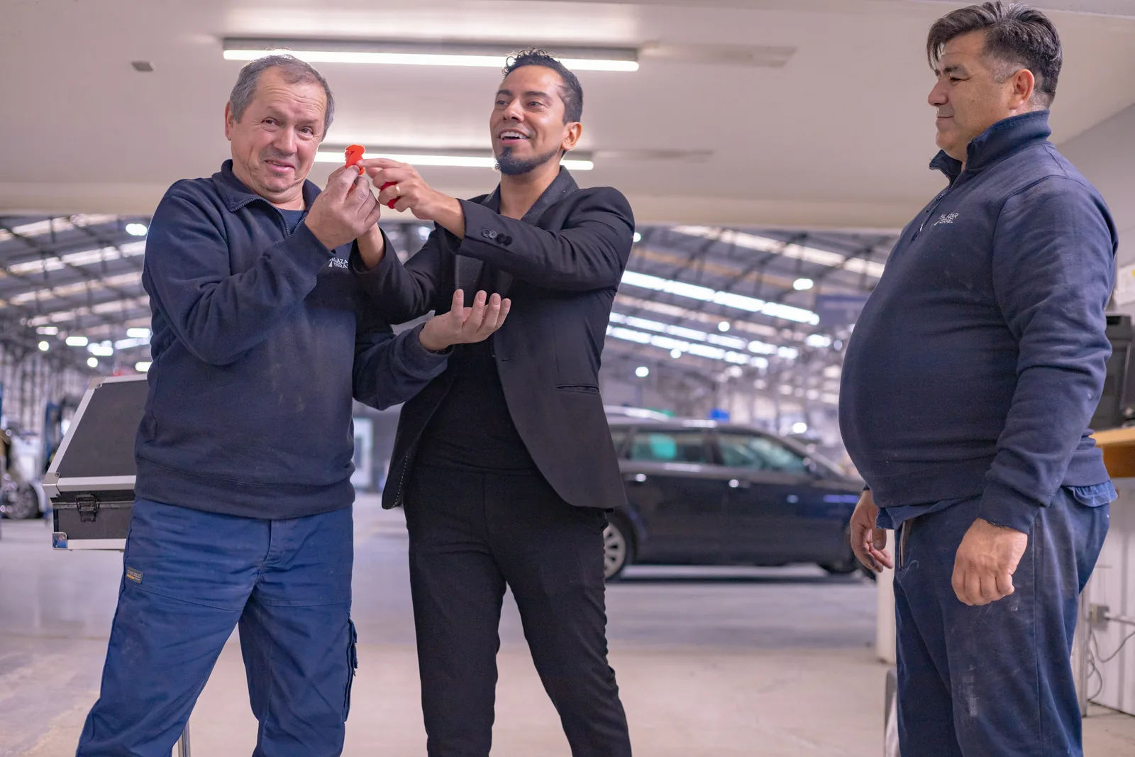 Rafael Santana realizando un efecto de magia con trabajadores durante una charla de prevención.