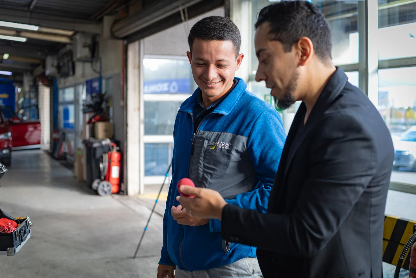 Rafael Santana realizando magia de cerca con un trabajador en un taller.