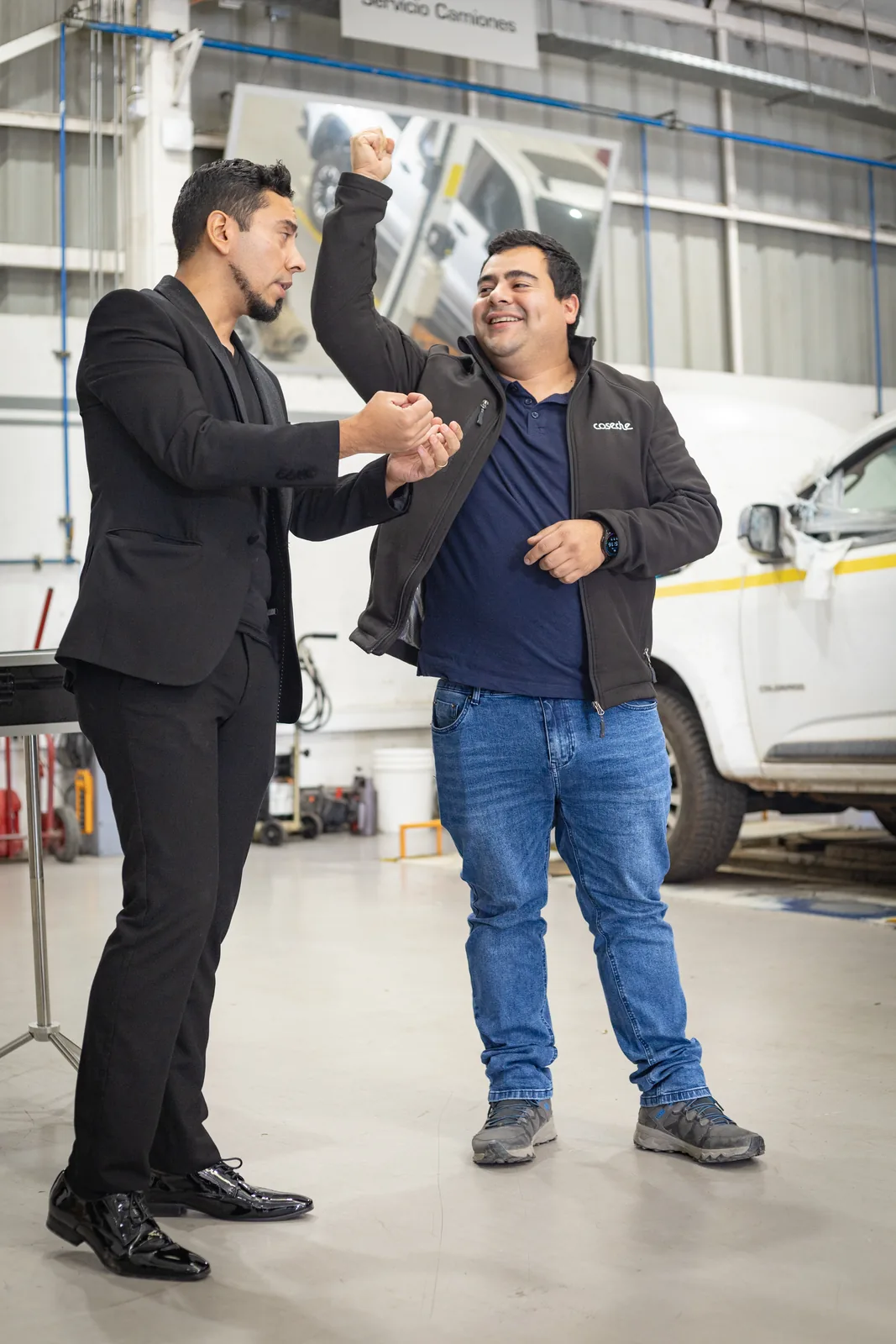 Rafael Santana realizando un efecto de magia con un voluntario en un taller industrial.
