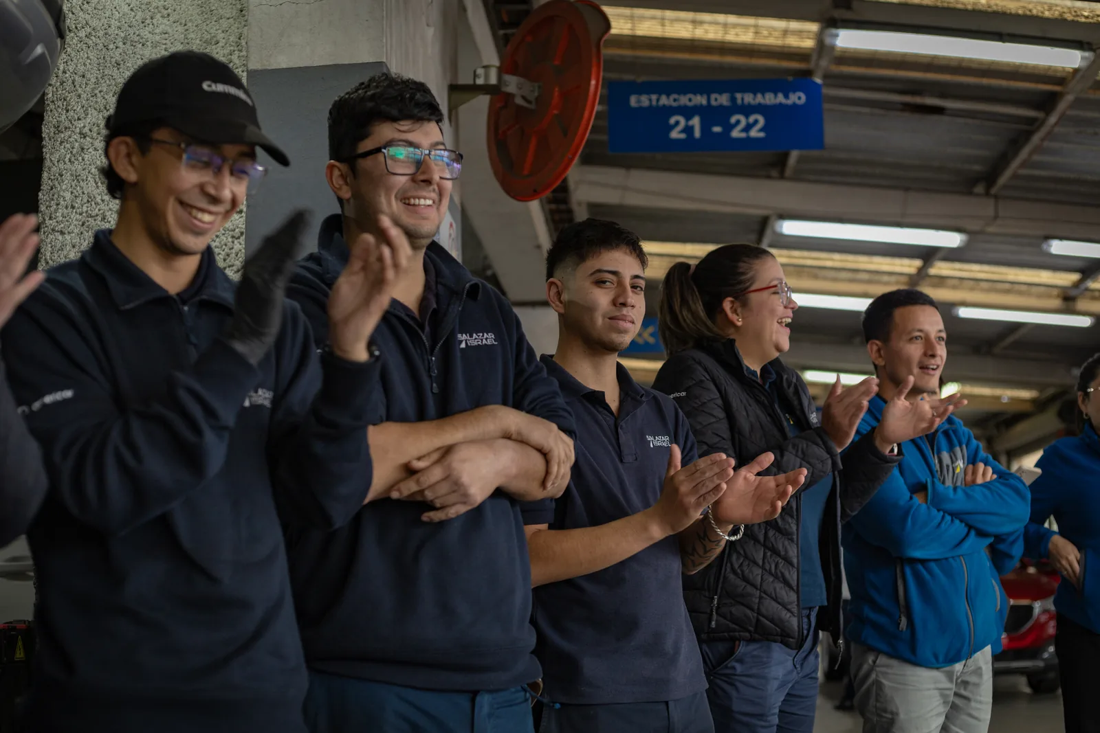 Trabajadores aplaudiendo durante una intervención de Magisteria en su lugar de trabajo.